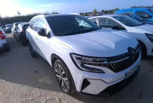 Renault Austral blanc nacré vu en 3/4 avant droit, avec calandre à damier noire et jantes alliage 20 pouces.