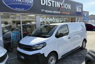 Vue 3/4 avant droite d’un Opel Vivaro blanc 2024 utilitaire avec calandre noire et jantes acier, devant un concessionnaire.