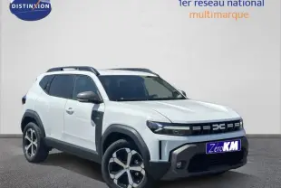 Vue 3/4 avant d'un Dacia Duster blanc Glacier 2025 avec jantes alu et barres de toit noires.