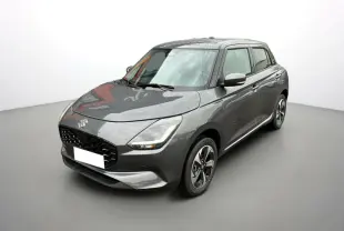 Suzuki Swift 2025 gris minéral vue 3/4 avant droit avec jantes alliage et phares LED allumés.