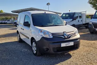Renault Kangoo blanc vue 3/4 avant droit avec pare-chocs noir mat sur un parking en extérieur.