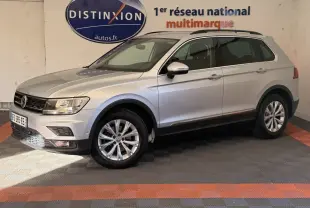 Volkswagen Tiguan gris clair vue de profil droit en intérieur avec jantes alliage et barres de toit noires.