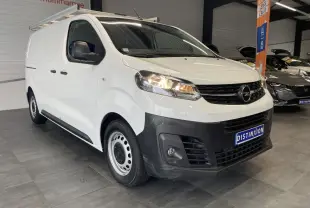 Opel Vivaro blanc en fourgon, vue 3/4 avant droit, avec boucliers noirs et jantes tôles 16 pouces.
