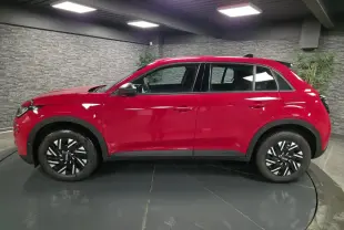 Profil côté gauche d'une FIAT 600 1.2 Hybrid rouge vif avec jantes 16'' bicolores et coques de rétroviseurs noires.