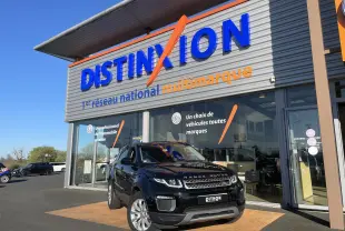 Range Rover Evoque noir en 3/4 avant droit devant un showroom avec enseigne Distinxion visible.