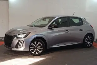 Peugeot 208 électrique gris clair vue de profil côté gauche, avec phares LED et jantes stylisées.