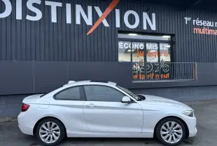 Profil droit d'une BMW Série 2 blanche de 2015, coupé compact avec toit ouvrant et jantes alliage visibles.