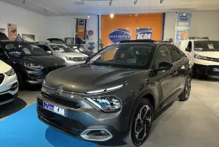 Citroën C4 gris platinium métal vue 3/4 avant droit dans un showroom avec éclairage intérieur.