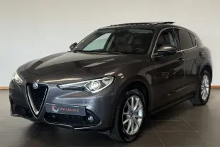 Alfa Romeo Stelvio gris vu de trois quarts avant droit, avec calandre caractéristique et jantes alliage.
