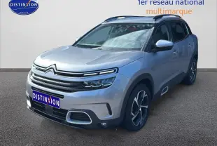 Citroën C5 Aircross gris Artense en 3/4 avant droit, avec jantes alu et barres de toit noir brillant.