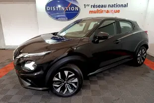 Nissan Juke noir en vue 3/4 avant droit, avec jantes alliage bicolores et phares LED ellipsoïdaux visibles.