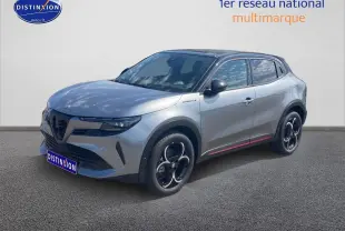 Vue 3/4 avant droite d'une Alfa Romeo Junior gris t/noir avec jantes alliage et vitres teintées.