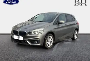 BMW Série 2 Active Tourer 216dA gris platine vue 3/4 avant droit avec jantes alu et feux allumés.