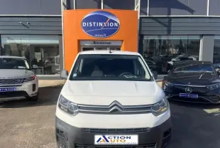 Vue frontale d'un Citroën Berlingo blanc Banquise avec calandre distinctive, garé devant un concessionnaire.