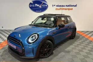 Vue 3/4 avant d'une MINI Cooper bleu avec toit ouvrant panoramique et jantes noires en intérieur showroom.
