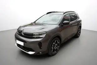 Citroën C5 Aircross gris platinium en 3/4 avant droit, avec jantes alu 18 pouces et barres de toit visibles.