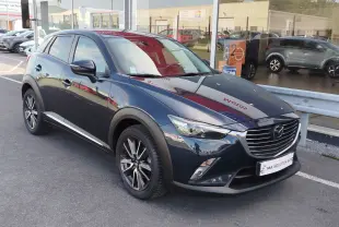 Mazda CX-3 2016 bleu Dynamic Blue Mica en 3/4 avant droit, avec jantes alliage et calandre chromée.