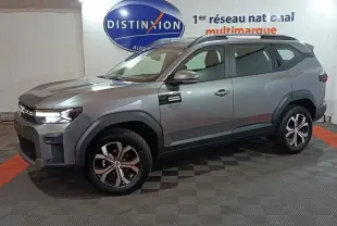 Vue 3/4 avant droit d'un Dacia Bigster gris foncé avec jantes alliage et détails noirs contrastants.