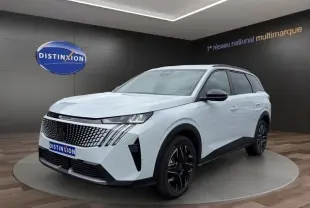 Peugeot 5008 blanc vue 3/4 avant droit en intérieur, avec calandre noire et jantes noires distinctives.