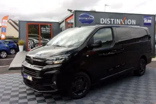 Vue 3/4 avant gauche d'un Citroën Jumpy XL noir Perla avec jantes noires, stationné devant un showroom Distinxion.