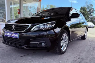 Peugeot 308 SW noire métal vue 3/4 avant droit sous abri avec jantes alliage et calandre distinctive