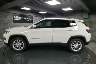 Jeep Compass blanc en profil côté gauche, avec jantes alliage 18 pouces et vitres arrière surteintées.