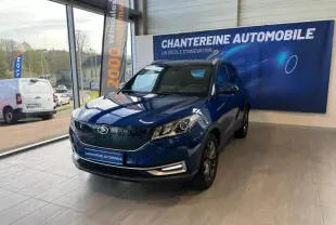 Vue 3/4 avant d'un SUV SERES 3 Electric 163ch Luxe bleu astral métallisé exposé en showroom avec bannière publicitaire.