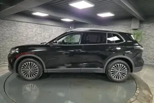 Vue de profil côté gauche du Volkswagen Tiguan noir 2025 avec jantes alliage 18 pouces et toit ouvrant.