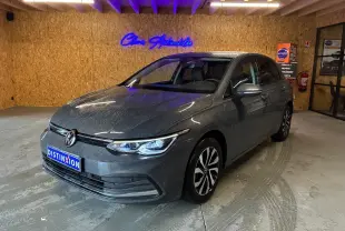 Volkswagen Golf 1.5 eTSI gris vue 3/4 avant droit dans un garage avec éclairage intérieur.