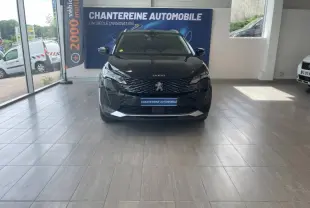 Vue frontale d'un Peugeot 5008 noir Perla Nera exposé en showroom avec calandre chromée et logo lion visible.