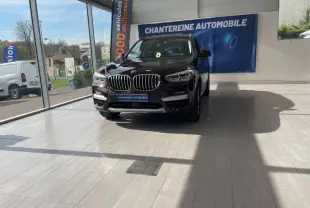 BMW X3 xDrive30e Saphirschwarz vue de face en intérieur, mettant en valeur la calandre et les phares LED.