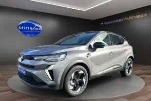 Vue 3/4 avant d'un Renault Captur 2025 gris Cassiopée avec toit noir et jantes distinctives en concession.