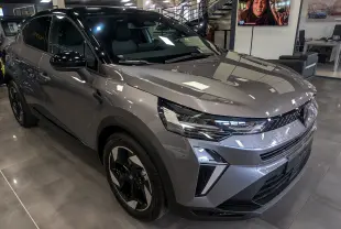 Renault Captur 2025 gris Cassiopé à toit noir, vue 3/4 avant droit, avec jantes biton et éclairage LED distinctif.
