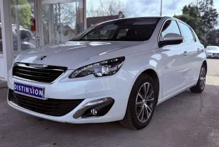 Peugeot 308 blanc nacré vue 3/4 avant droit, avec jantes alliage et calandre noire brillante.