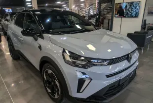 Renault Captur Mild Hybrid gris Rafale avec toit noir, vue 3/4 avant droit en showroom lumineux.