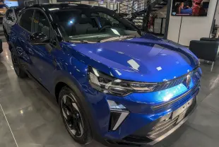 Renault Captur 2025 bleu Iron avec toit noir, vue 3/4 avant mettant en valeur ses phares LED et jantes biton.
