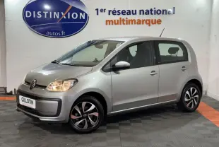 Volkswagen Up gris foncé vue 3/4 avant droit, phares allumés et jantes noires et argentées design moderne.