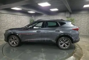 Vue de profil côté gauche d’un CUPRA Formentor gris métallisé avec jantes alliage 18'' et bas de caisse noir contrastant.