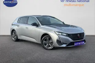 Peugeot 308 Gris Artense vue 3/4 avant droit, avec calandre noire distinctive et jantes alliage.