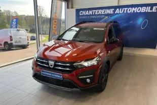 Dacia Jogger brun Terracota métallisé en 3/4 avant droit dans un showroom avec logo Chanteraine Automobile en arrière-plan.