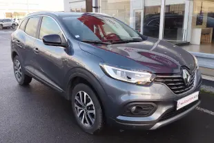 Renault Kadjar gris titanium en 3/4 avant droit, avec jantes bi-ton et calandre noire brillante.