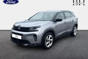 Citroën C5 Aircross gris acier en 3/4 avant droit, avec jantes alu et détails noirs brillants sur carrosserie.