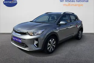 KIA STONIC gris météore en 3/4 avant droit, avec jantes bi-ton et toit ouvrant visible sur fond neutre.