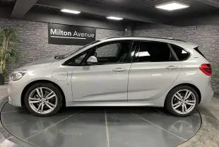 BMW Série 2 225xe Active Tourer hybride gris vue de profil côté gauche en intérieur showroom