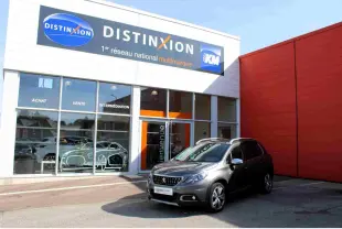 Peugeot 2008 gris Artense en 3/4 avant droit, avec barres de toit aluminium et jantes 17 pouces diamantées.