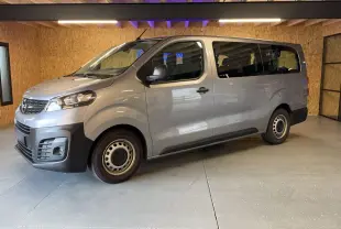 Vue 3/4 avant droit d'un Opel Vivaro Combi gris 2022 avec jantes acier et pare-chocs noirs dans un garage.