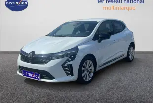 Renault Clio blanche vue 3/4 avant droit, avec calandre noire et feux LED distinctifs, stationnée devant un mur clair.