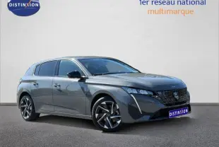 Peugeot 308 gris en 3/4 avant droit, mettant en valeur sa calandre distinctive et ses jantes modernes.