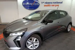 Renault Clio Evolution Blue dCi 100 gris clair vue 3/4 avant droit avec phares LED allumés en intérieur showroom.