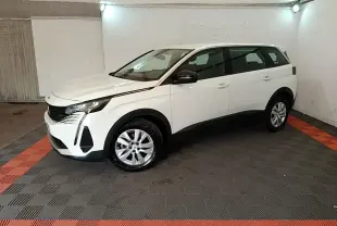 Peugeot 5008 blanc vue de profil côté gauche dans un garage avec jantes argentées et feux LED avant.